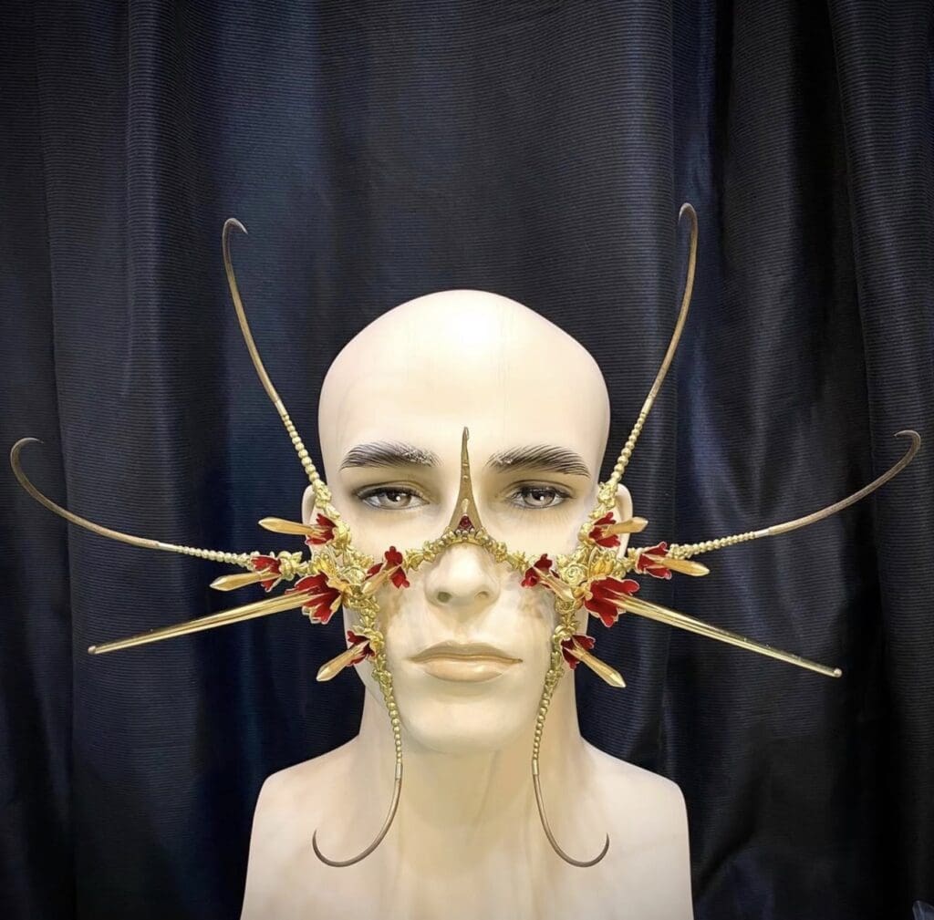 A gold mask with red flowers created by Lance Victor Moore.