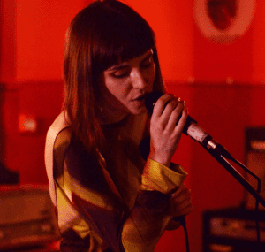 A woman singing with a microphone.